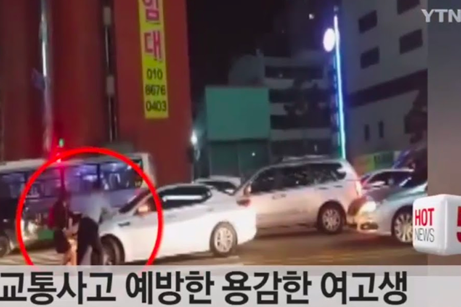 韓國晚間交通事故現場，顯示勇敢的女子與警察一起預防交通意外的情形。