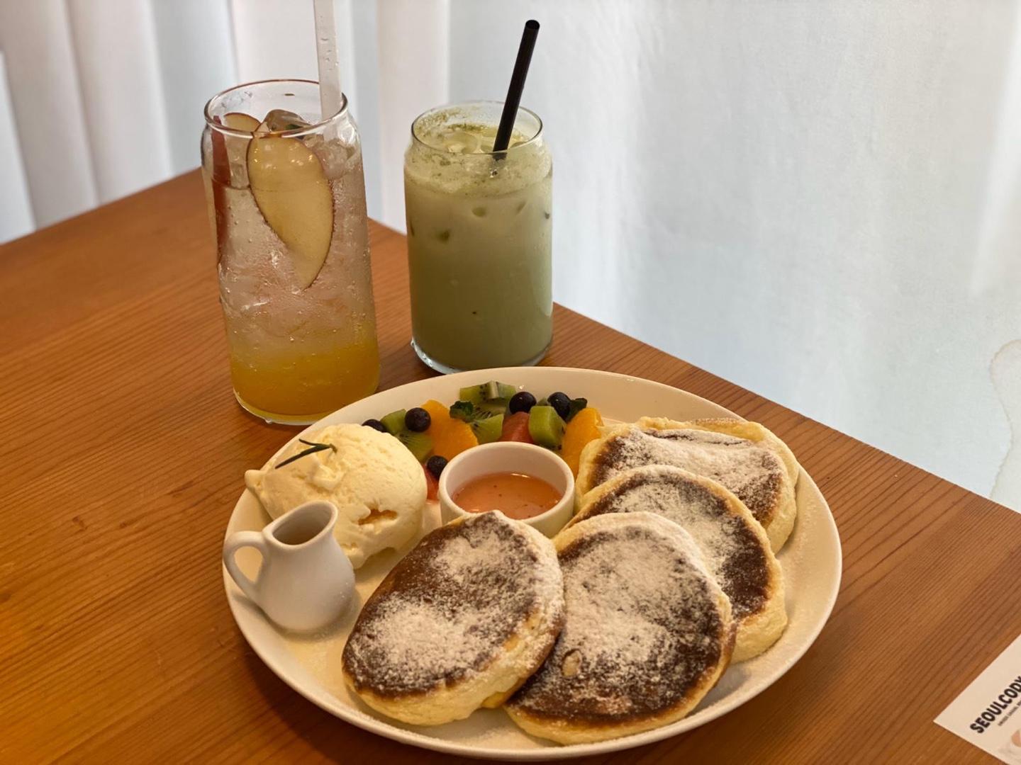 2SOYOU Café的經典鬆餅搭配新鮮水果和飲品，放在餐桌上