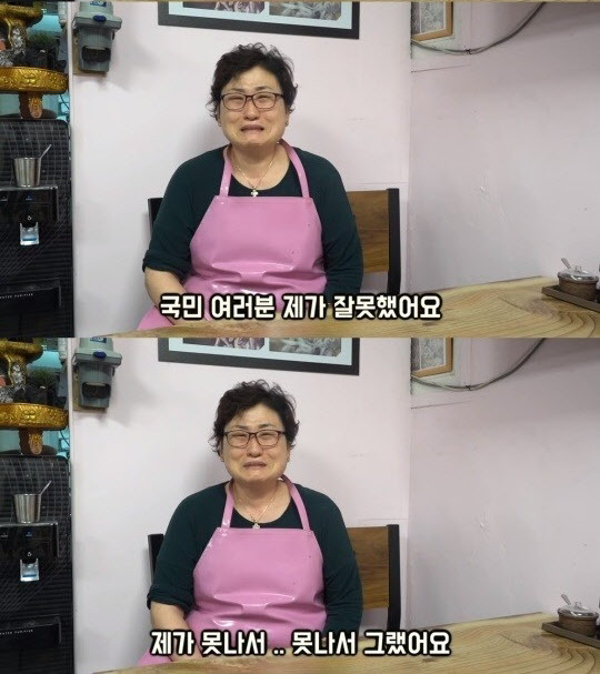 身穿粉色圍裙的餐廳老闆坐在桌子前。