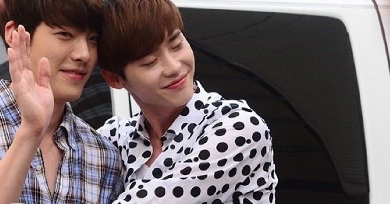 兩位韓國男孩在户外肩並肩站立，一位男孩穿著格子襯衫，另一位則穿著圓點襯衫。