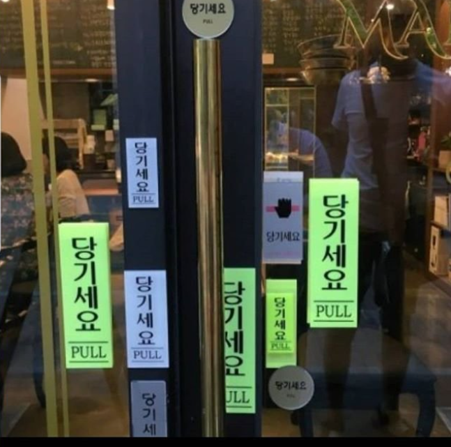 韓国の店舗ドアにある大量の'당기세요 (引いてください)'のステッカー - SEO対策向けALTテキスト