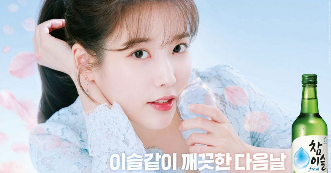 韓國燒酒廣告海報, 展現一位女性模特手握酒杯, 背景柔和粉色, 與飲品品牌搭配呼應