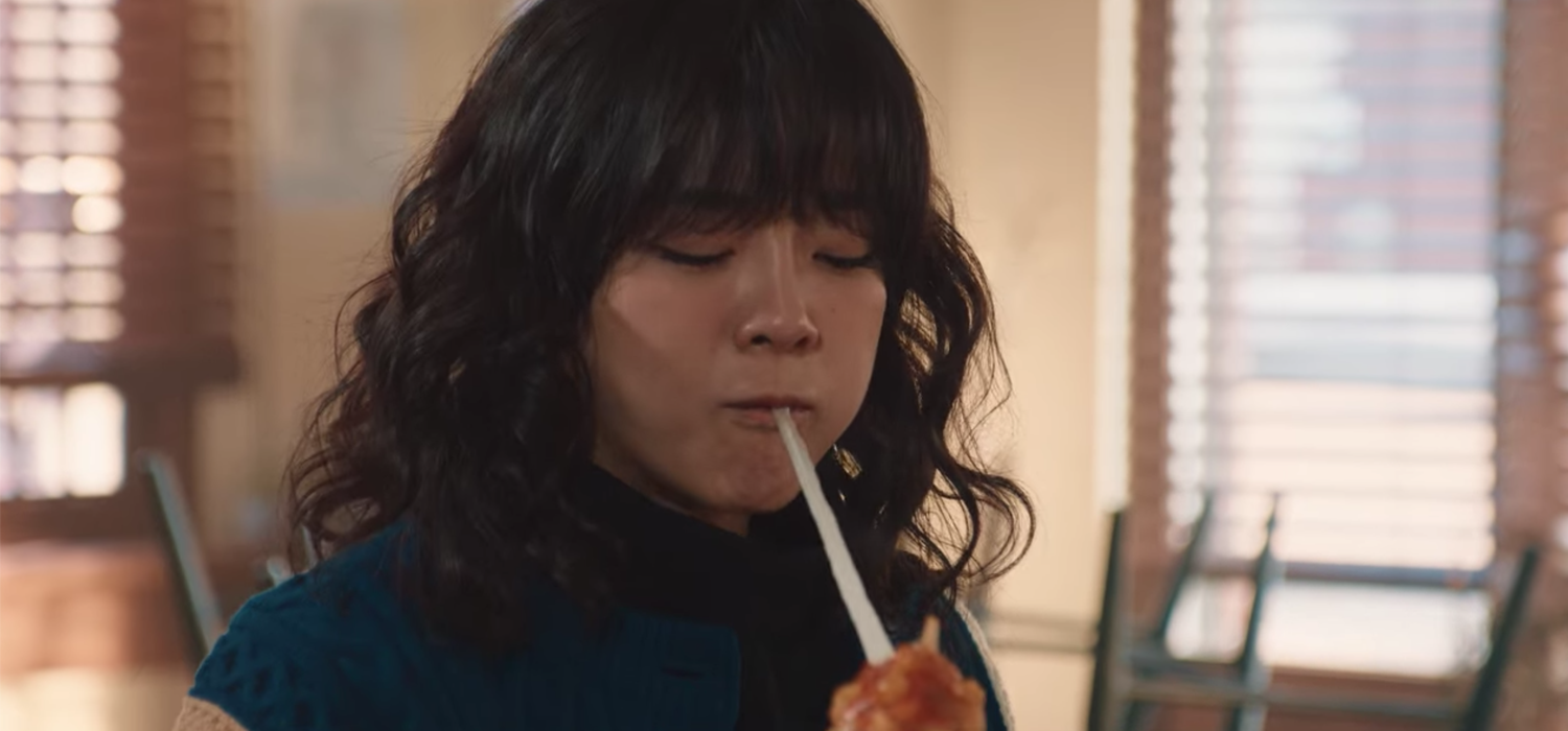 一位女子品尝韩国明朗热狗，感受特殊的食物体验