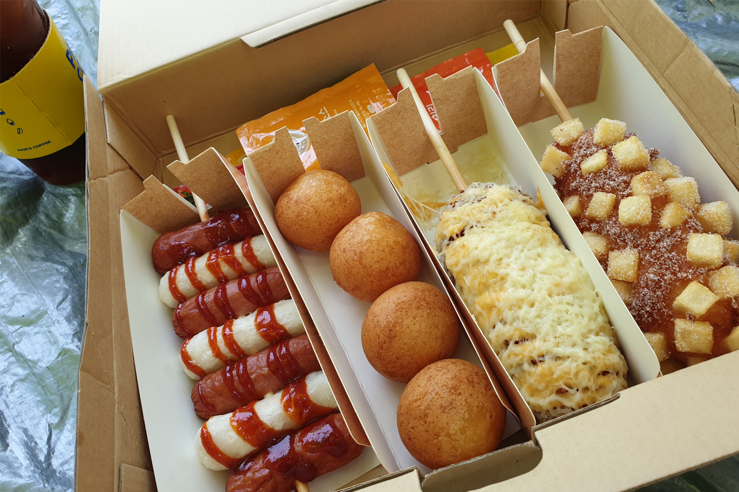 明朗热狗套餐近距离视角，展示各式美食及包装细节