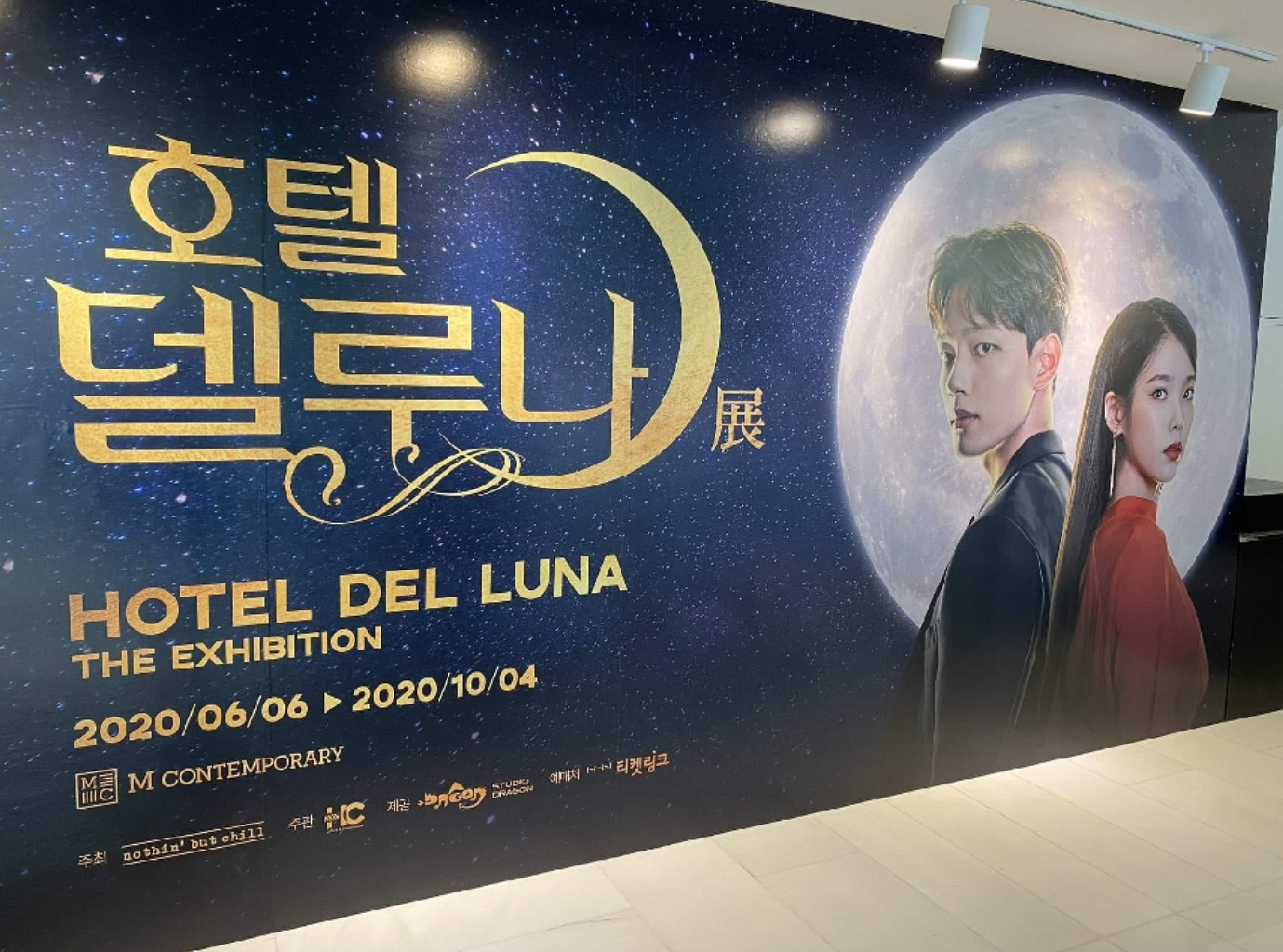 ホテルデルーナ展の内部壁に貼られたポスター。主人公が月を背景にしたビジュアルで、展示会の情報が記載されている。