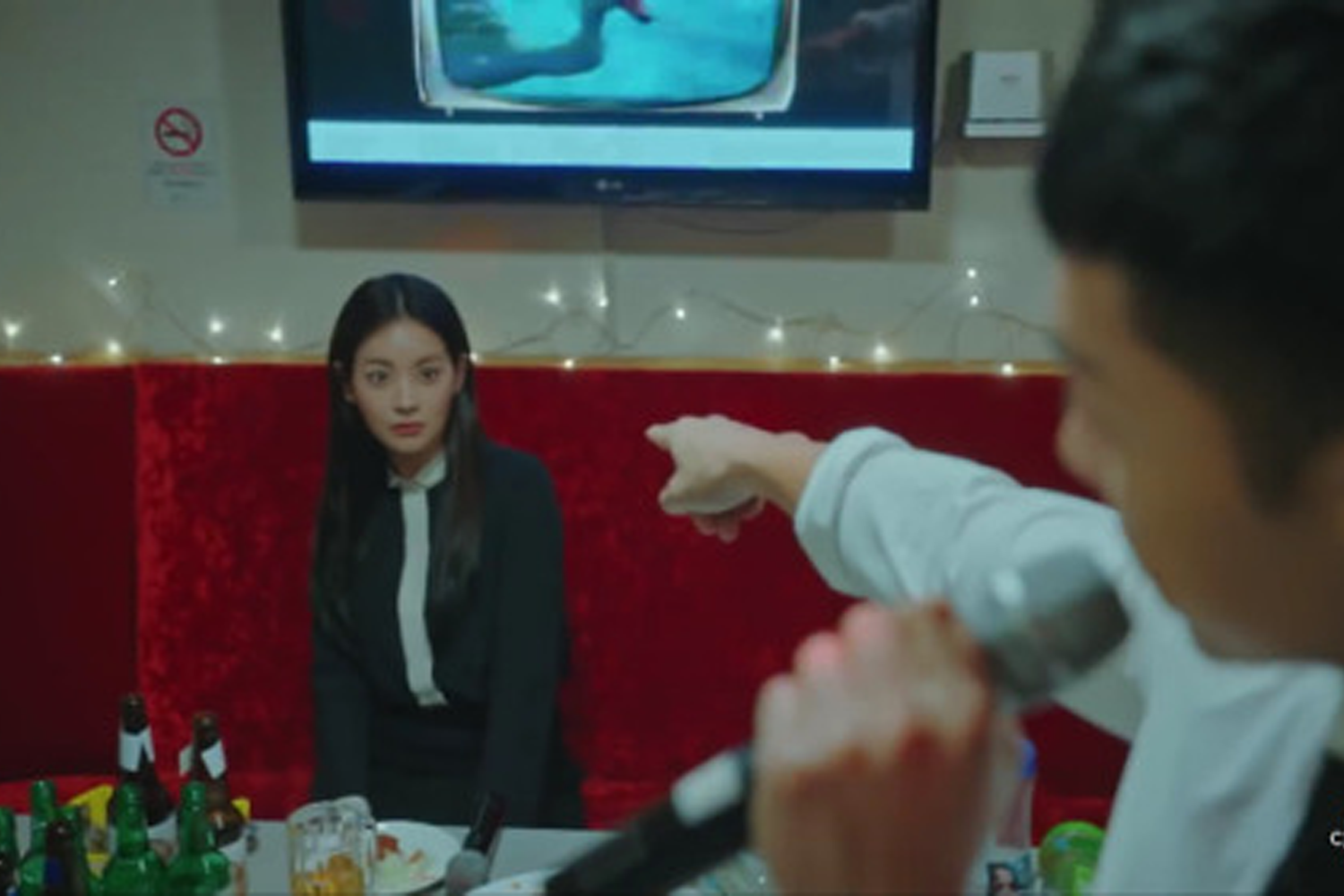 韓國卡拉OK房間中，兩名男子正在盡興演唱和跳舞。