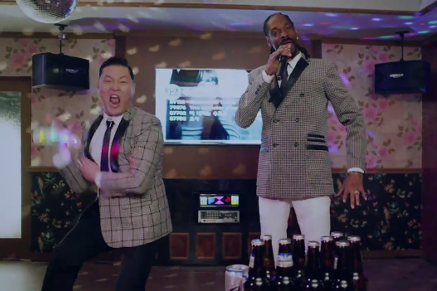 韓國卡拉OK內，桌上有啤酒瓶和小吃，背景有電視屏幕。