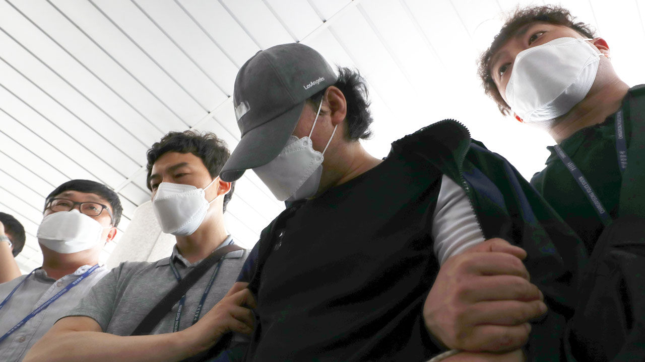 韓國，被捕嫌犯在警察護送下朝前走。