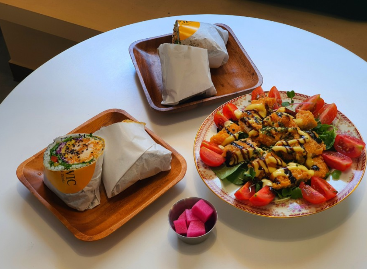 Lowicカフェで提供される料理のセット、フレッシュなサラダと巻かれたブリトーが並んでいる。