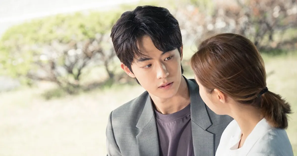 一对韩剧角色在公园中进行亲密对话，情景温馨，代表韩国电视剧中的常见情感互动场景。