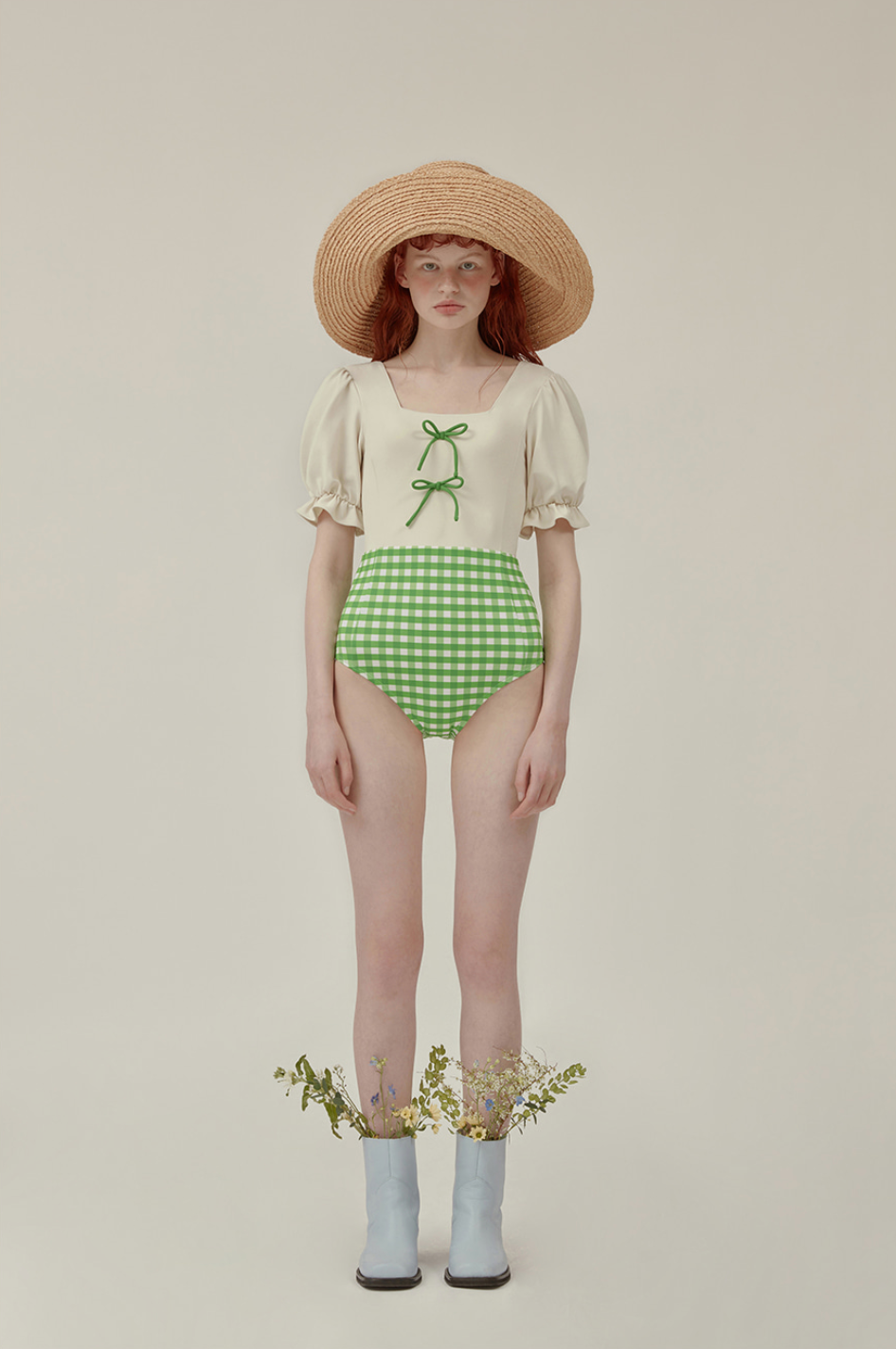 白色和綠色方格設計的泳裝搭配草帽的模特兒