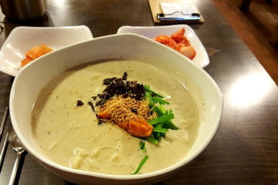 韓國豆漿冷麵配合豆漿湯、海苔和橙色蔬菜作為點綴，鹹甜口感是夏日獨特的味覺享受。