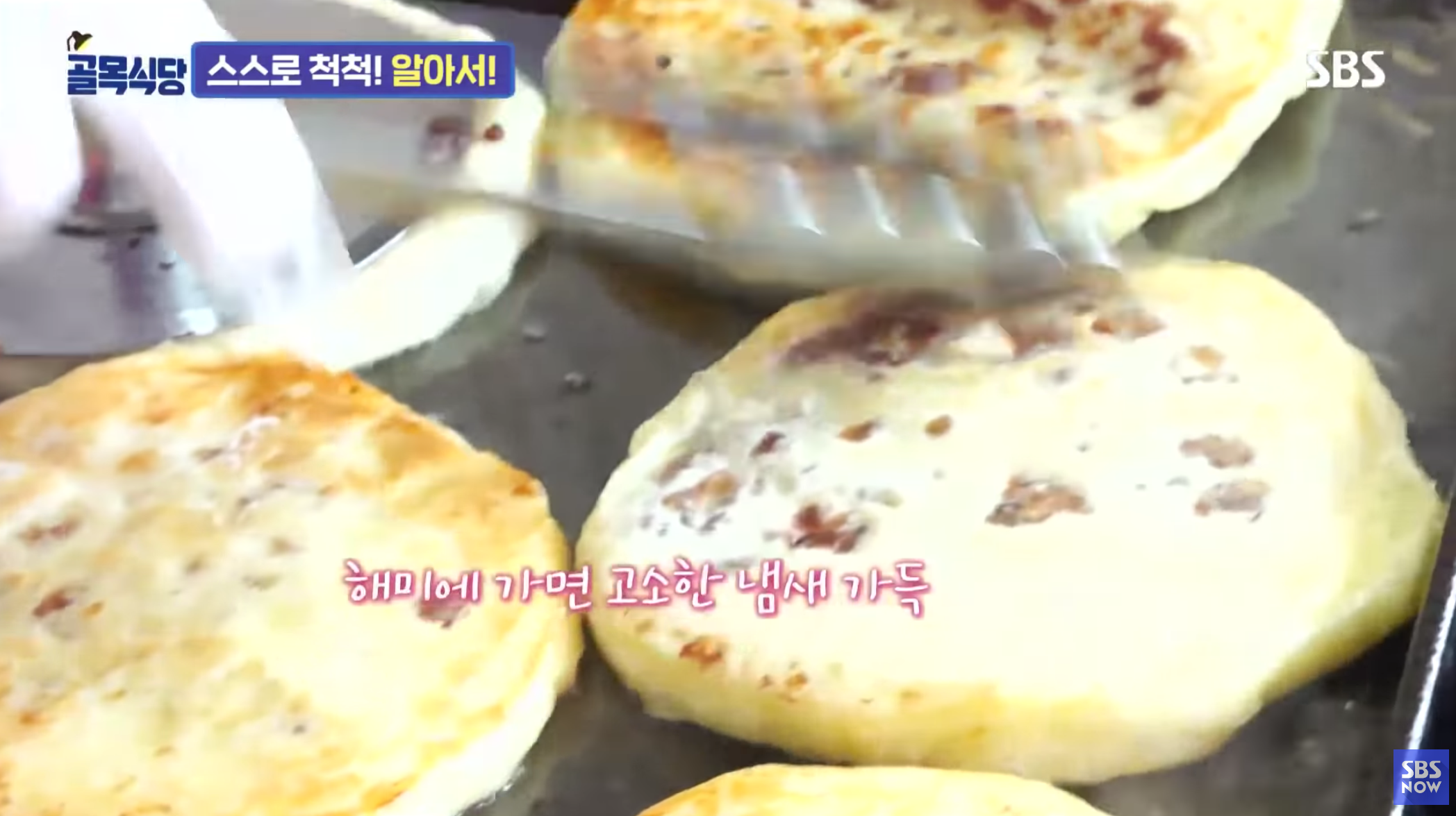 正在煎烤的海美糖饼，表面金黄酥脆，散发着诱人的香味。