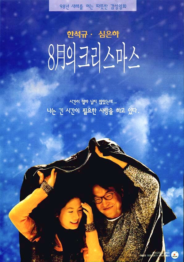 1998年韓國經典電影《八月照相館》的海報,背景為蔚藍的天空和白色雲朵,充滿浪漫氛圍。