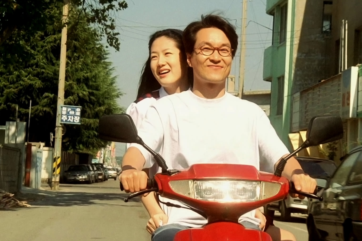 韓國經典電影《8月照相館》劇照，男主角面對命運努力改變的場景.