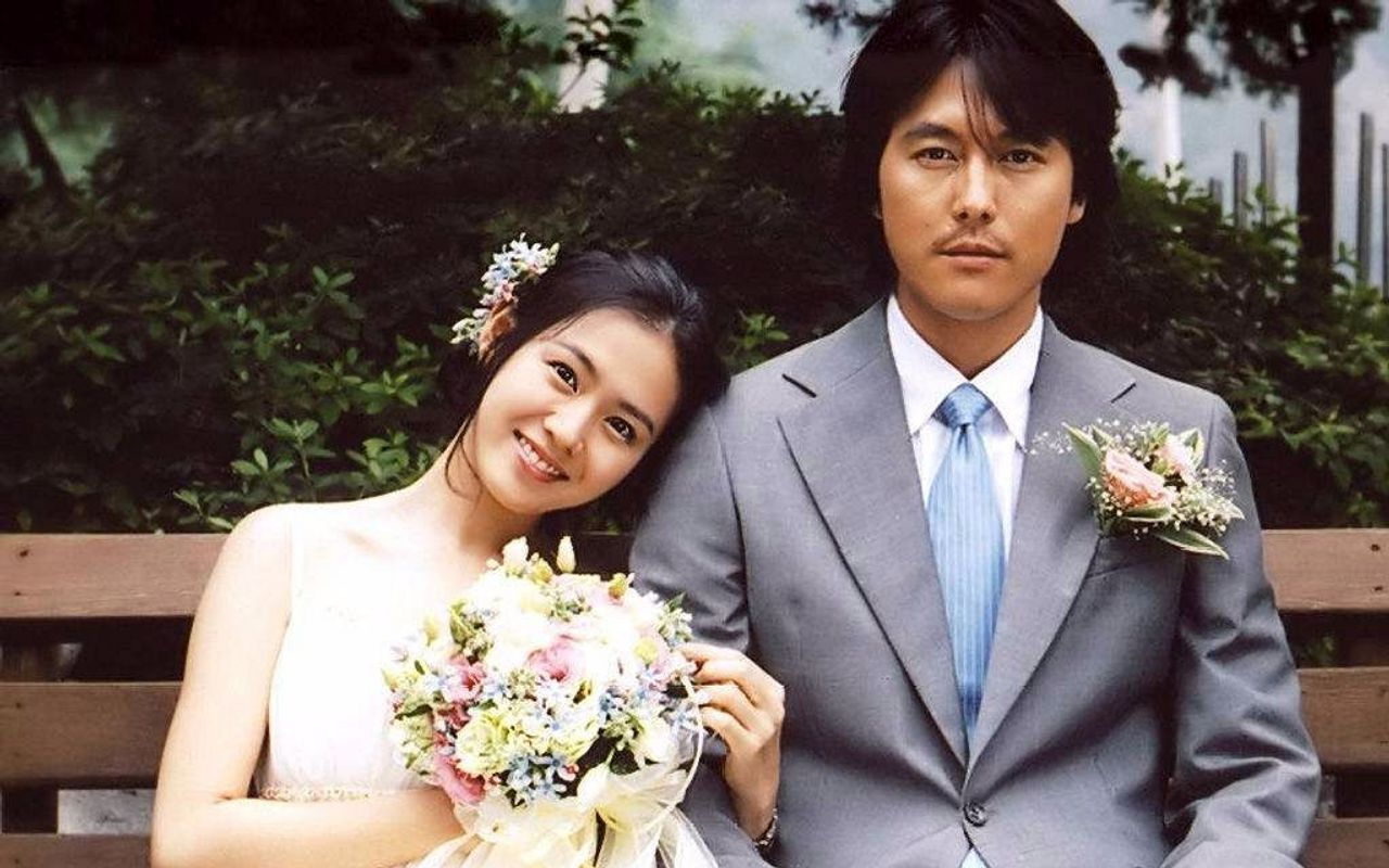 韓國電影《我腦海中的橡皮擦》中,新人夫婦坐在長椅上,周圍綠樹環繞,象徵愛情的幸福與美好。