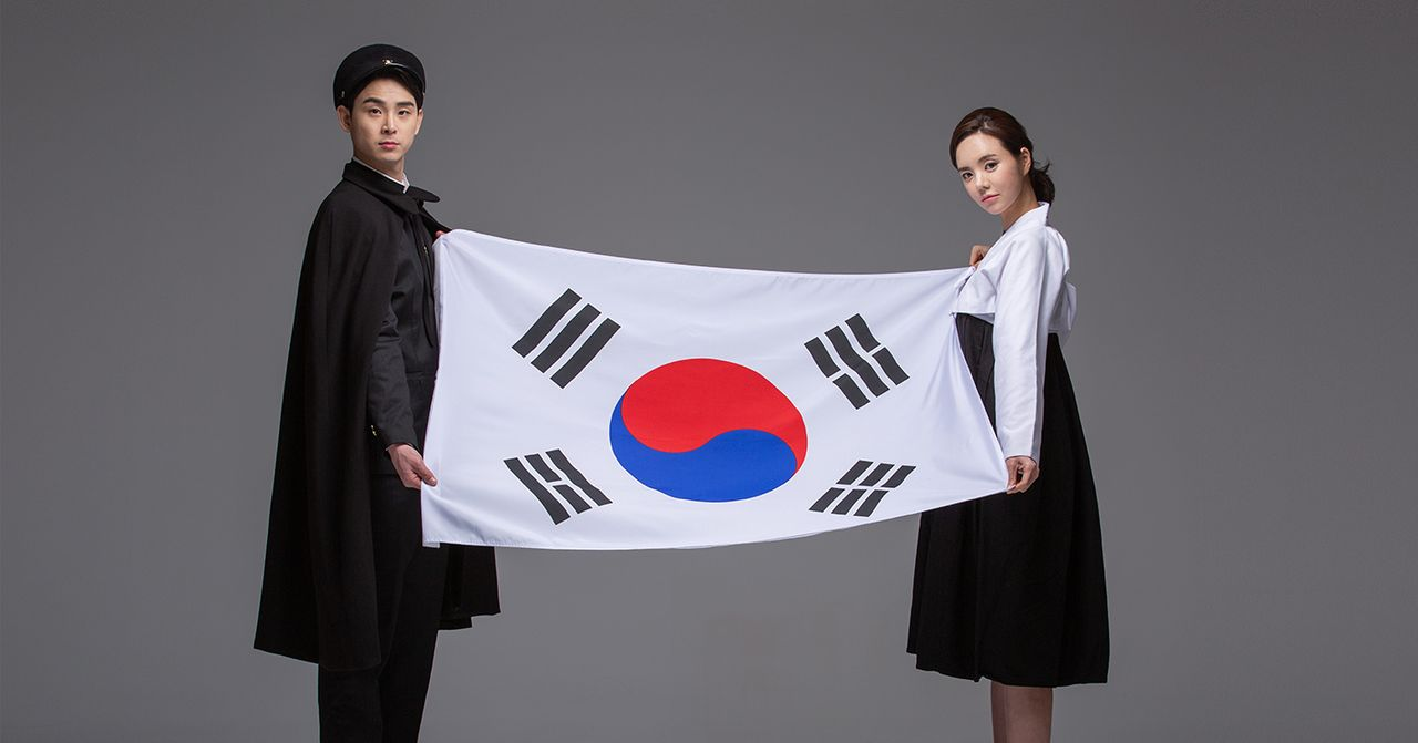 两位穿着传统韩服的模特展示着韩国国旗，以光复节为主题。