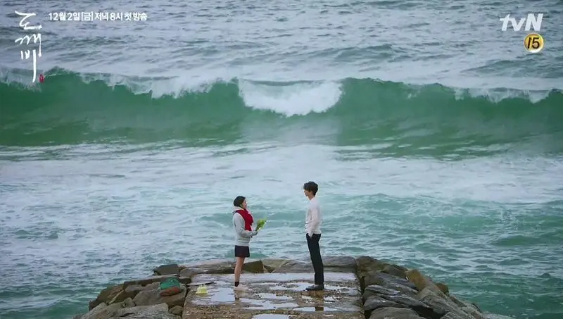 Iconic Goblin drama scene at the edge of a jetty with ocean waves in the background, Jumunjin Beach.