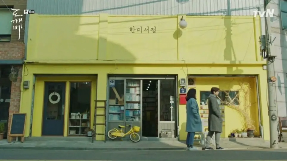 Hanmi Bookstore, Goblin filming location, Incheon, yellow storefront with two characters standing.