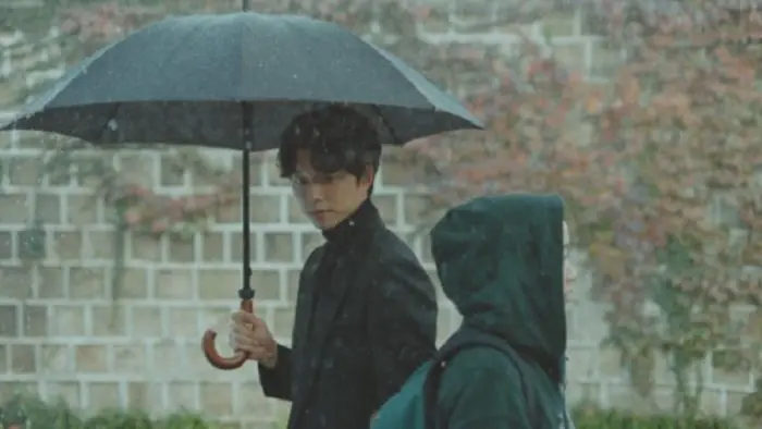 Character holding an umbrella walking in the rain near Deoksugung Stonewall Walkway, Goblin scene.