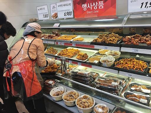 ที่ขายอาหารสำเร็จรูปในซุปเปอร์มาร์เก็ตเกาหลี แสดงเห็นการจัดวางผลิตภัณฑ์อาหารให้เลือกซื้อในช่วงลดราคา