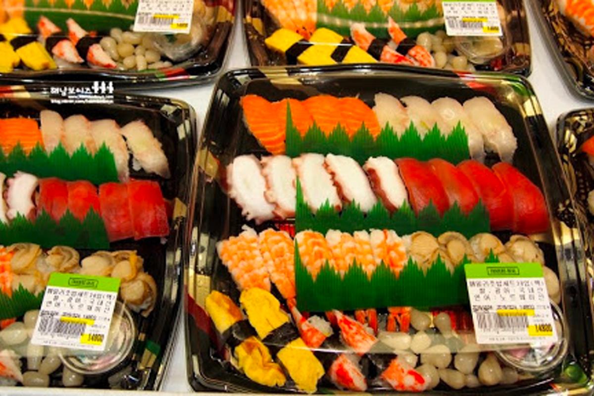 放滿壽司和其他熟食的韓國超市促銷區，常見於傍晚打折時段。