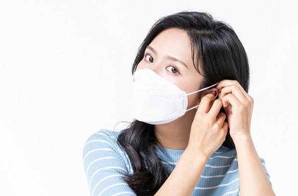 青いストライプのシャツを着た人がマスクを装着している様子。