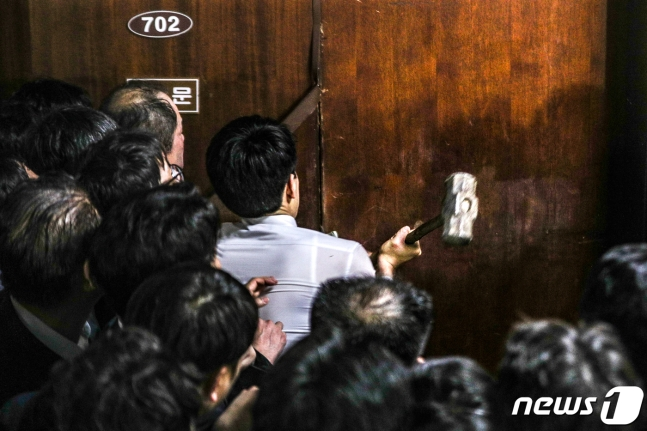 韩国议员在试图破坏议会大门的场景