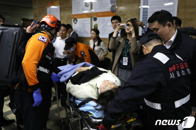 韩国议会中被送医的议员，周围有急救人员