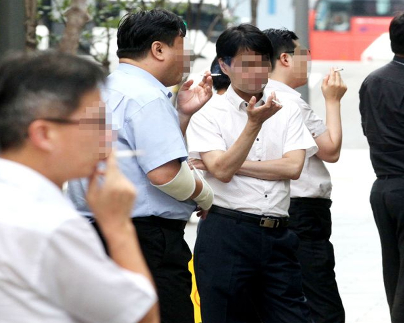 一羣在户外數名男子正在吸煙，反映韓國男性在公開場合的吸煙習慣。