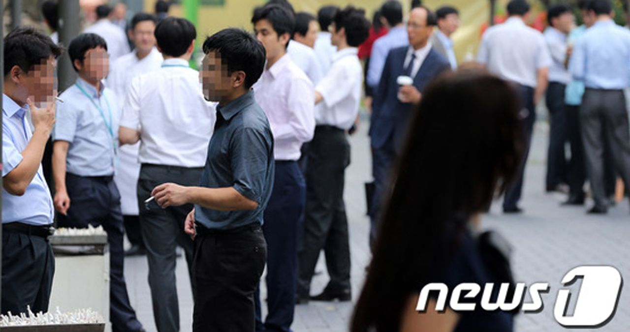 在韓國街頭,一群身著正裝的男士在公共區域抽煙,顯示韓國抽煙人口的街頭文化。