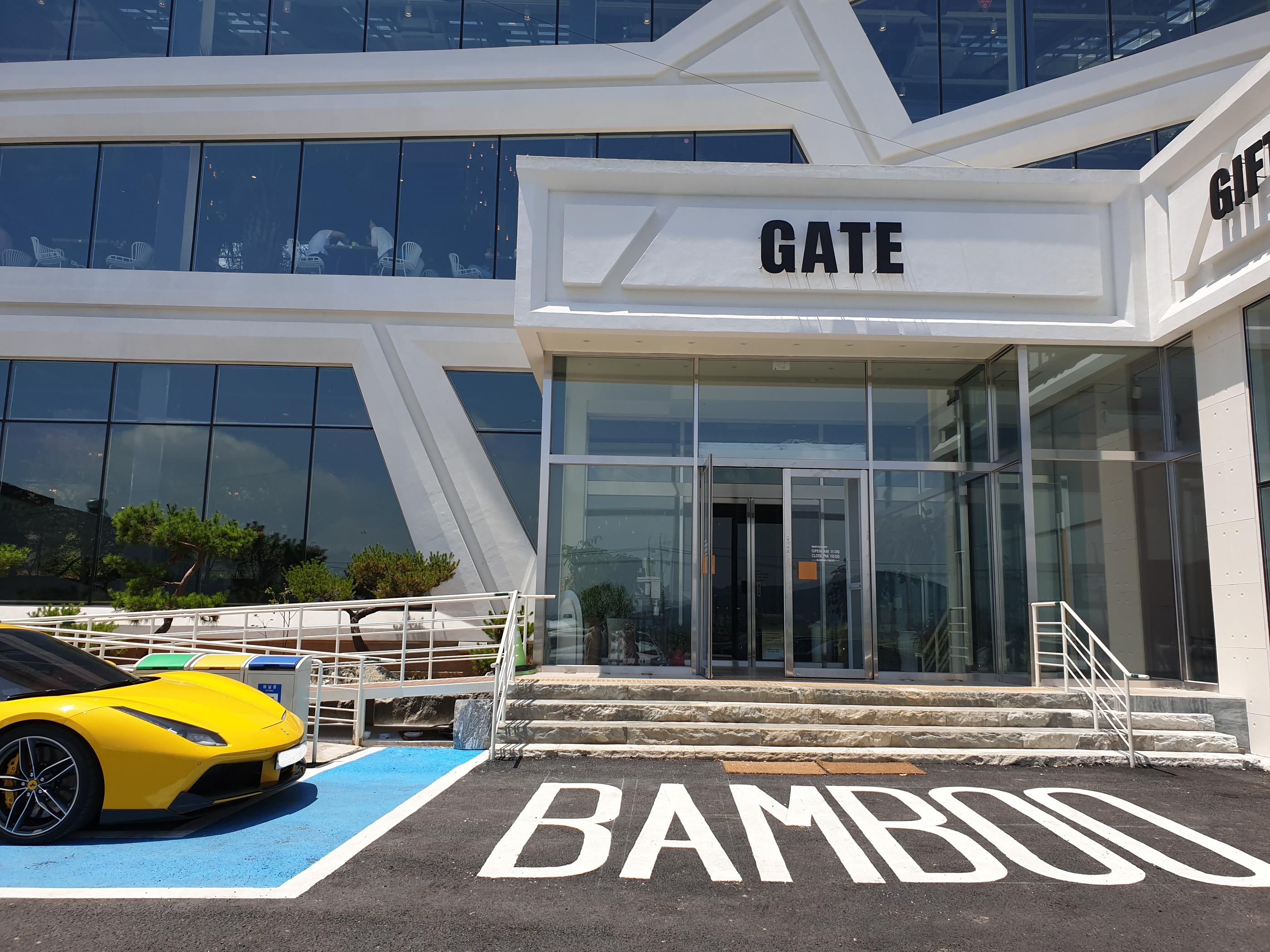 金浦のBAMBOO15-8カフェの入口。黄色い車が駐車されている前に「GATE」という看板が掲げられています。