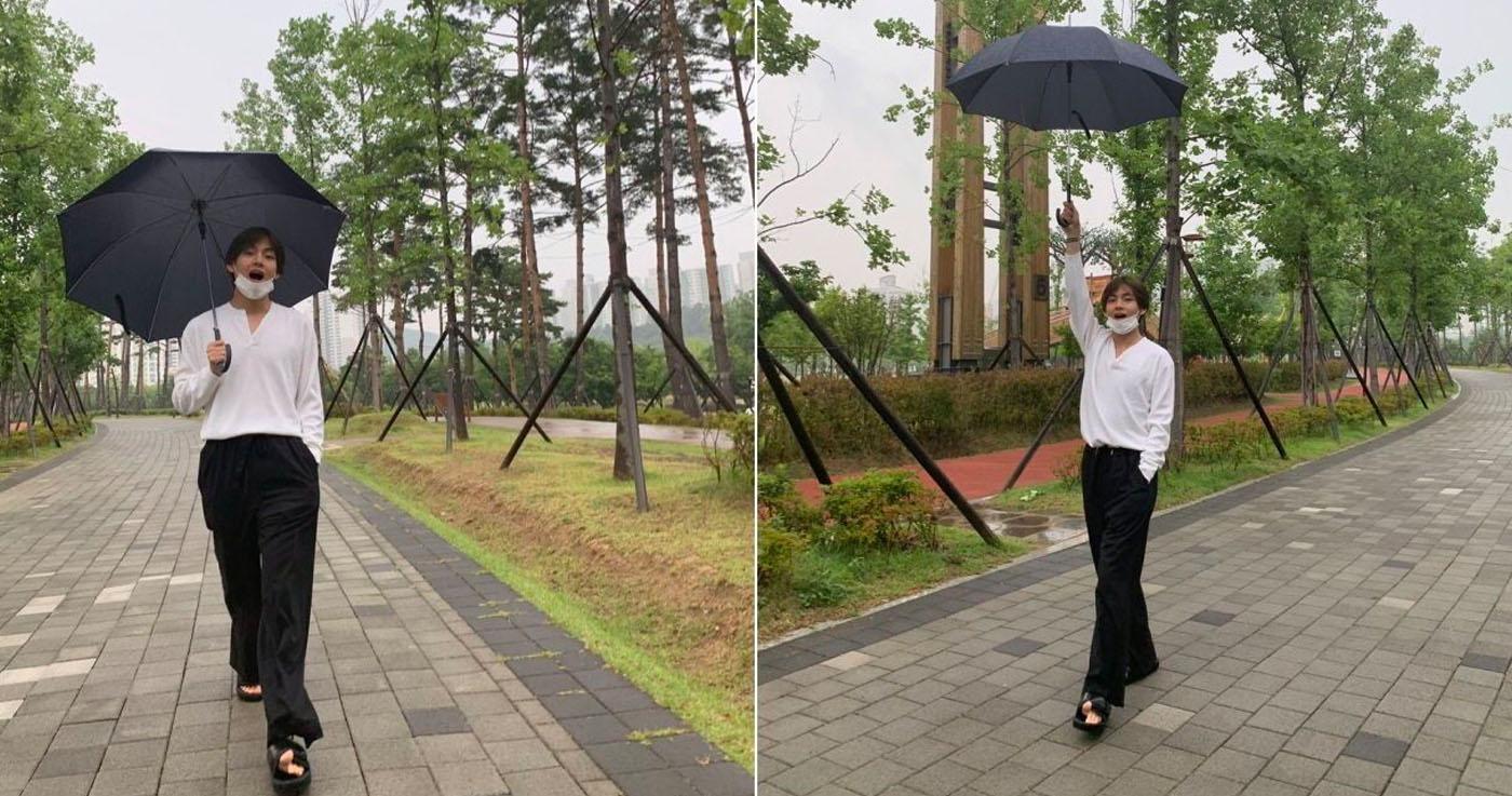 สมาชิก BTS เดินเล่นในสวนสาธารณะ ภายใต้ร่มสีดำในวันที่ฝนโปรยปราย แสดงถึงความเป็นส่วนตัวและสไตล์ที่เป็นเอกลักษณ์