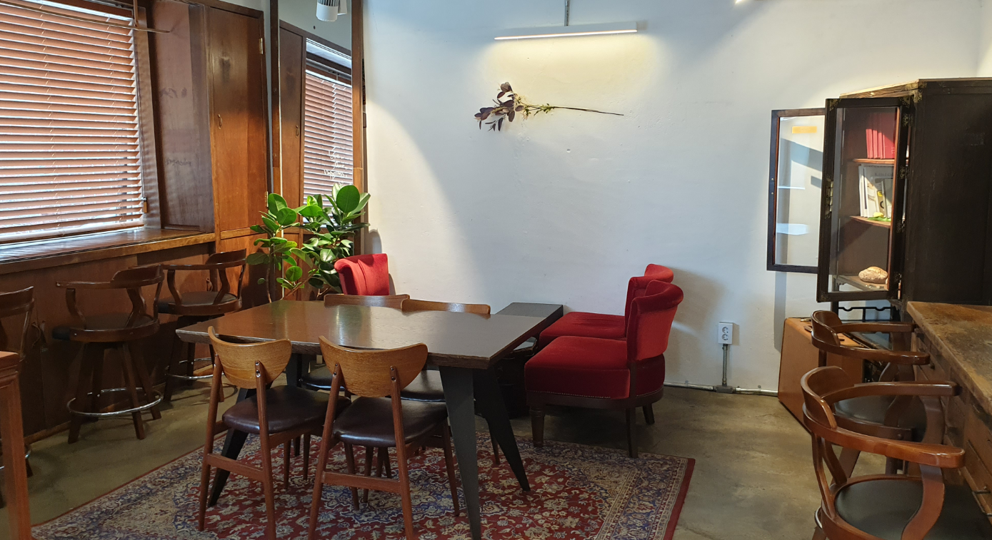 LALA BREADハンナム店のカフェエリア。木製傢俱と観葉植物が配置され、居心地の良い雰囲気を演出しています。