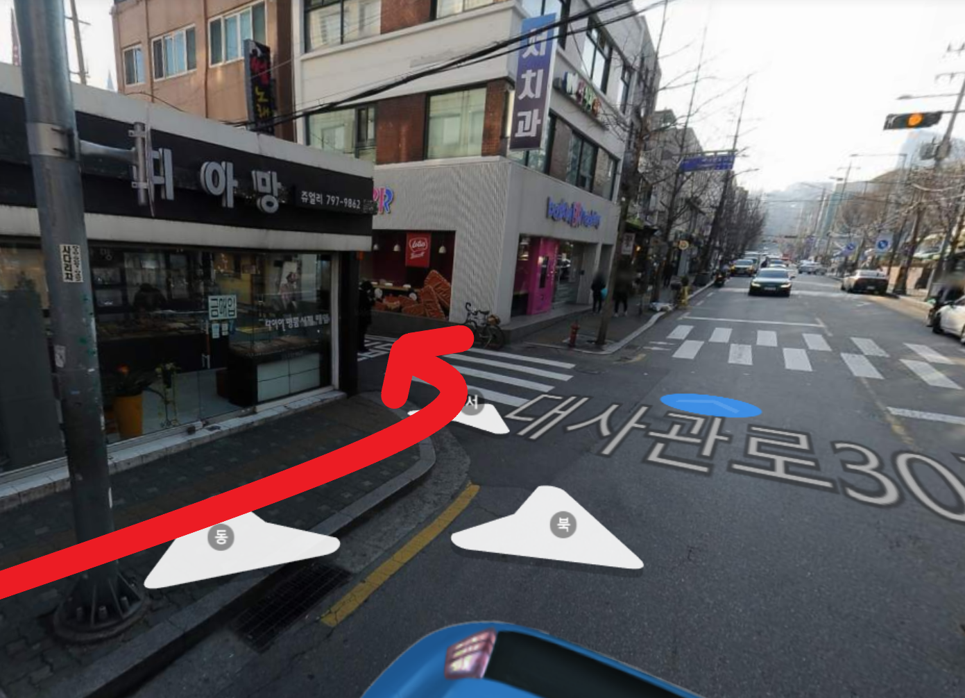 1つ目の曲がり角で左折することを示す画像。道の景色と赤い矢印が強調されています。