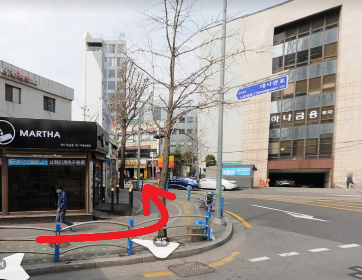 道をまっすぐ進んで左折する曲がり角を示す画像。道路の風景と赤い矢印が表示されています。