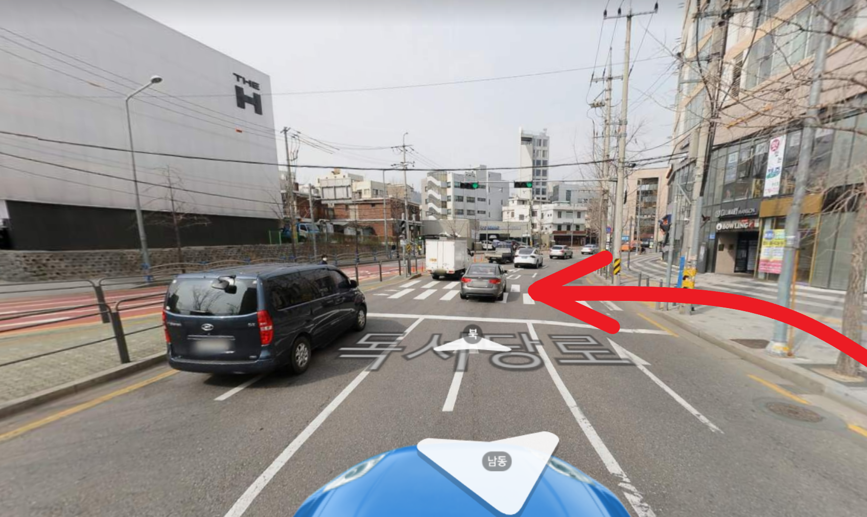 横断歩道を渡る際の道順を示す画像。道を横切る車や歩行者と交差点の標識が見えます。