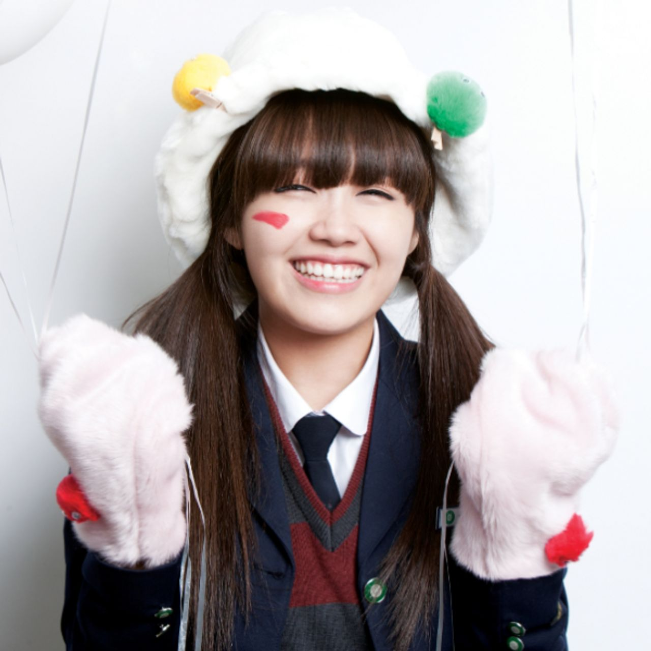 兩個人的合影，一個穿著校服，背景是白牆和白色的裝飾物。