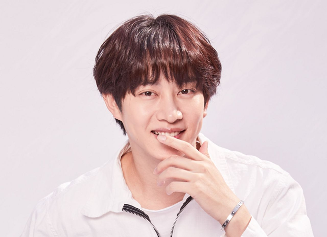 素描圖的肖像人在微笑，身著白襯衫，手抬起來似乎在思考。