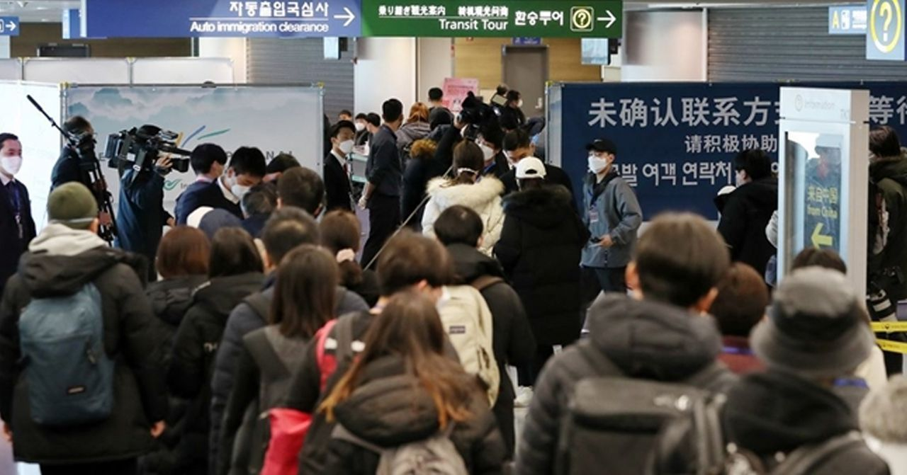 韓國疫情期間機場人羣排隊情景，顯示旅客穿戴口罩，取得通行證或登記的檢查程序。