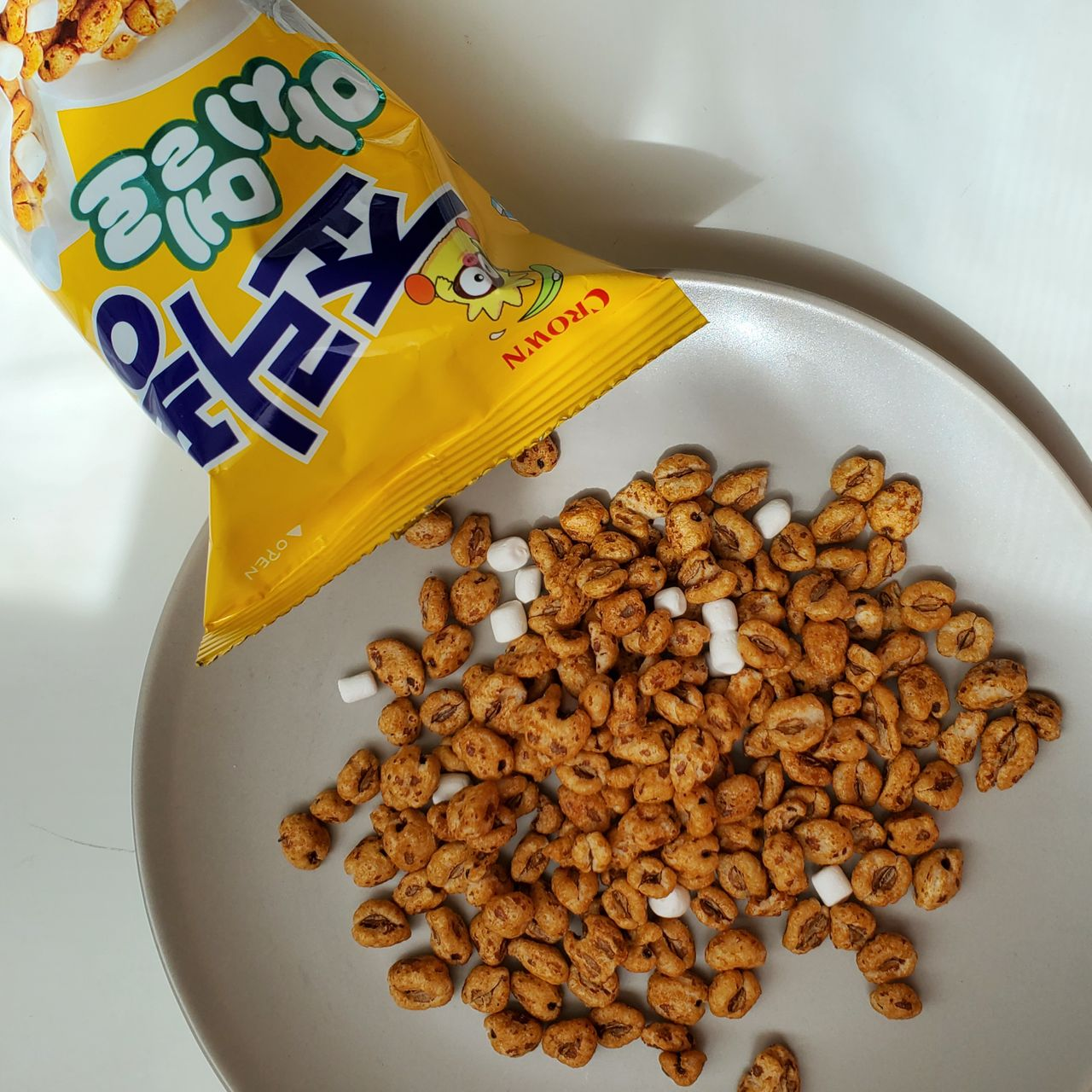 韓國죠리퐁的棉花糖口味開封後的穀物和棉花糖，放在一個白色盤子上。