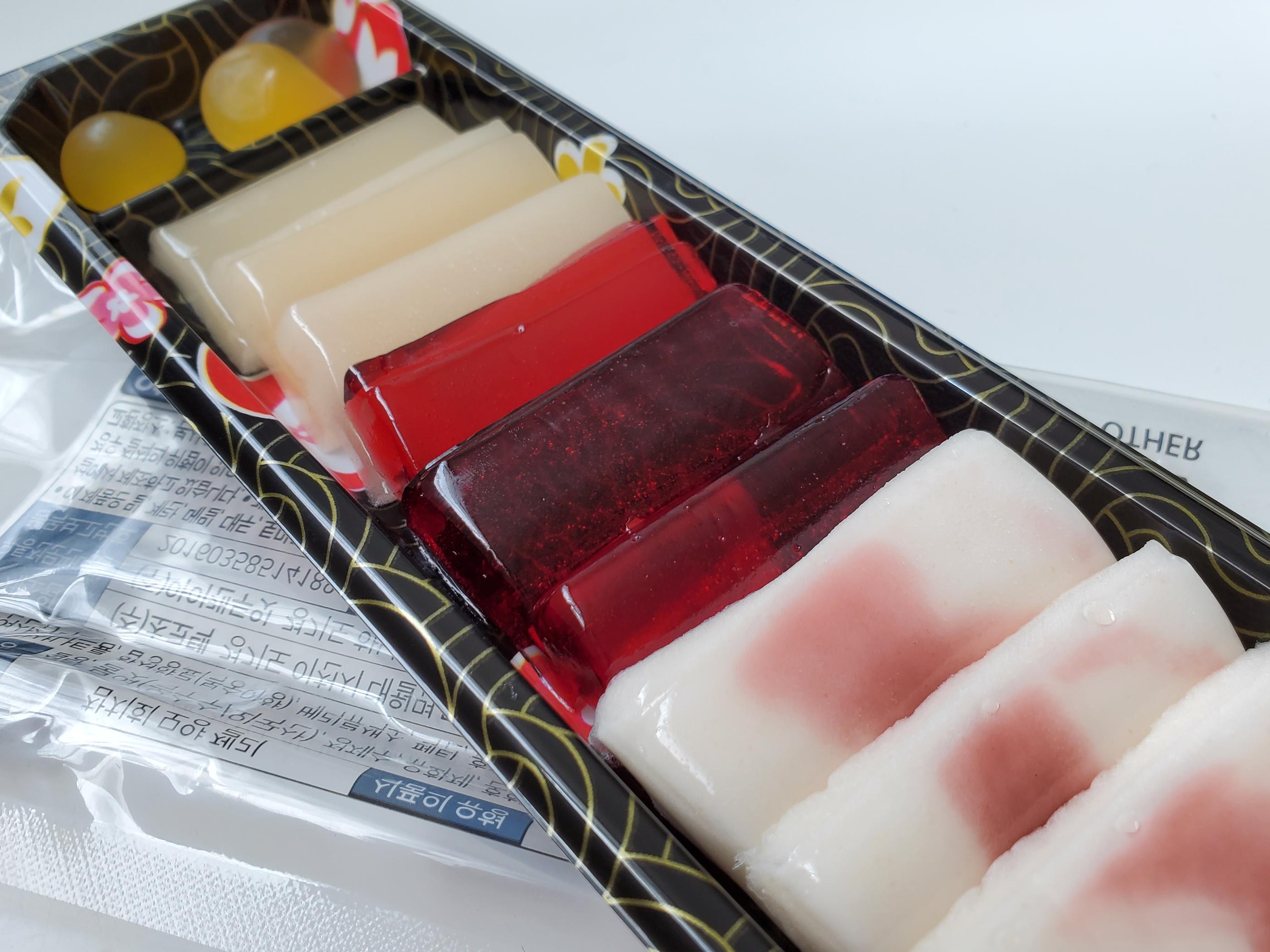 韓國吞拿魚生壽司軟糖的多種色彩和形狀，擺放在黑色漆器內。