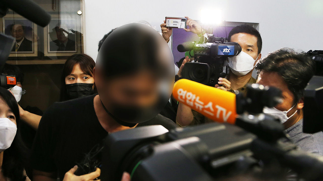 多家媒體記者採訪調查中的鐵人三項教練,背景有多支麥克風和攝影機。
