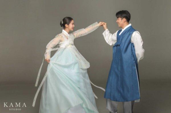 ウ・ヘリムとシン・ミンチョルの伝統的な韓国の衣装での撮影、ウ・ヘリムは女性の韓服を着ており、シン・ミンチョルは男性の韓服を着て夫婦としてポーズをとっている。