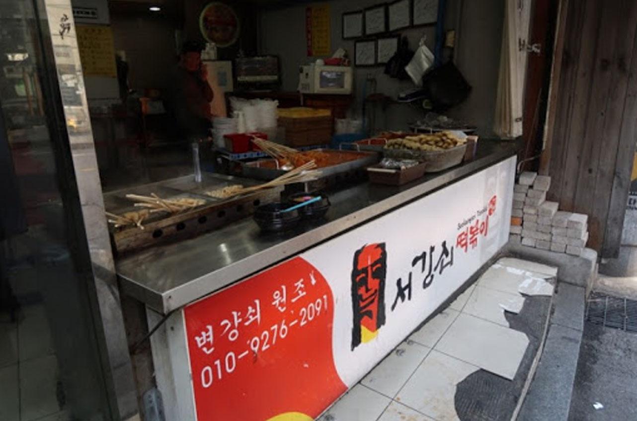 Interno del ristorante Seogangsoe Tteokbokki a Gangnam, Seoul, con tteok-bokki allineati per la preparazione.