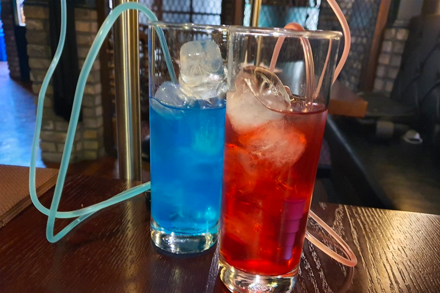 奇異的飲料選擇,幽藍色和紅色液體在玻璃杯中搭配,令人聯想到神秘的魔力藥水。