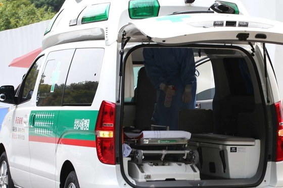 開著後門的救護車，準備進行急救搬運的場面，展示了救護車內部的裝備。