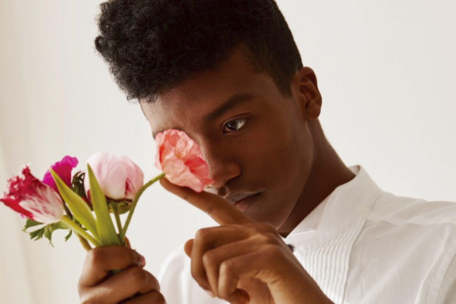 正在欣賞花朵的黑人男性，展示多樣性和個人獨特色彩。