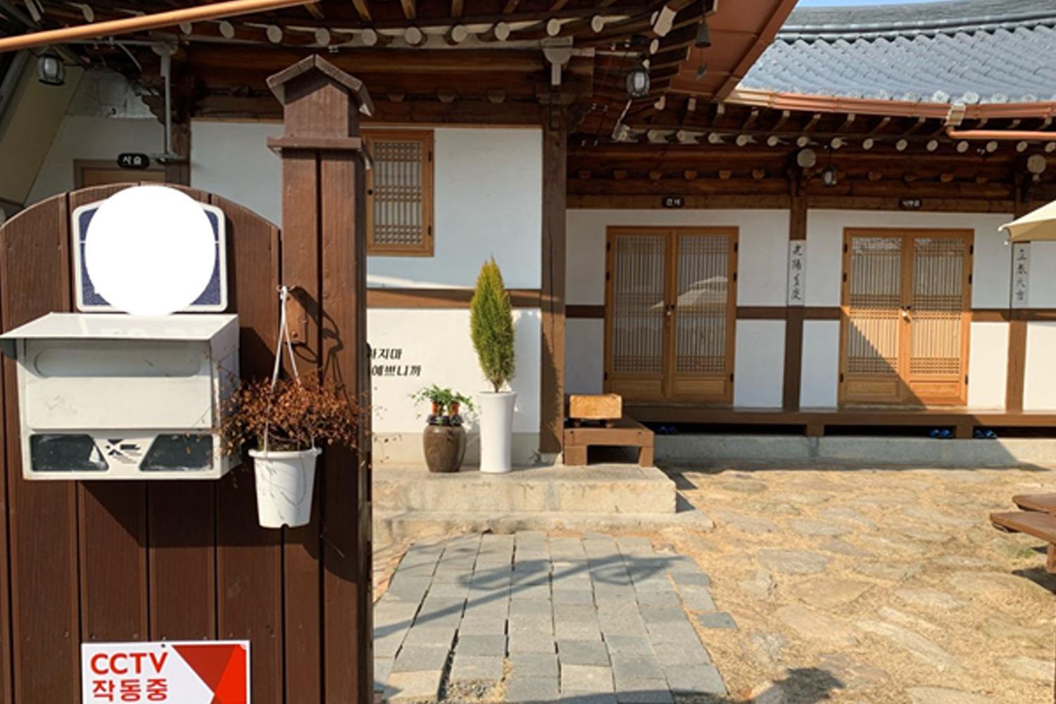 一座以韓屋改建的民宿，木質結構和門窗展現傳統韻味。