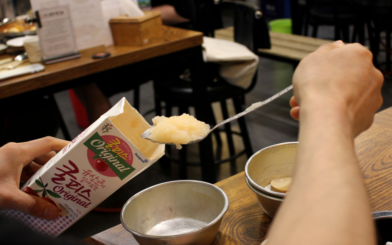 凍らせたクルピスをスプーンですくう様子。韓国料理店で食後に出されることもある、人気の凍った乳酸飲料。